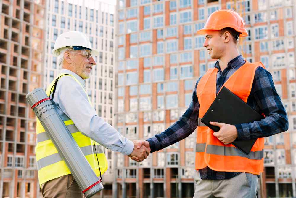 men with safety vest shaking hands